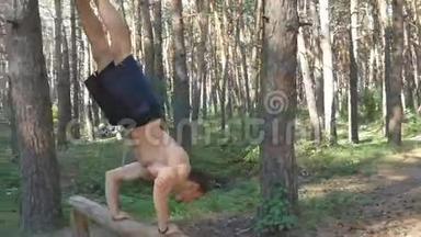 强壮的<strong>肌肉男</strong>在森林里做倒立。 <strong>肌肉男</strong>健身男在木头上做特技。 运动员